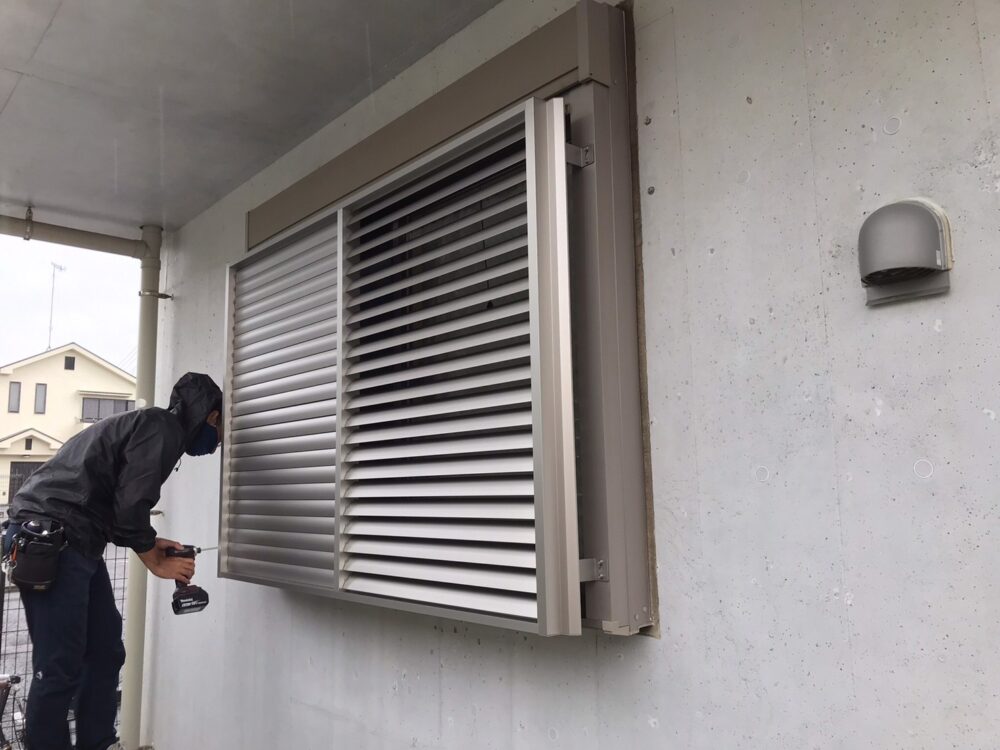 海老名トーヨー住器の職人による多機能ルーバー面格子の取り付け工事風景。専用ブラケットでシャッター窓へ後付け。