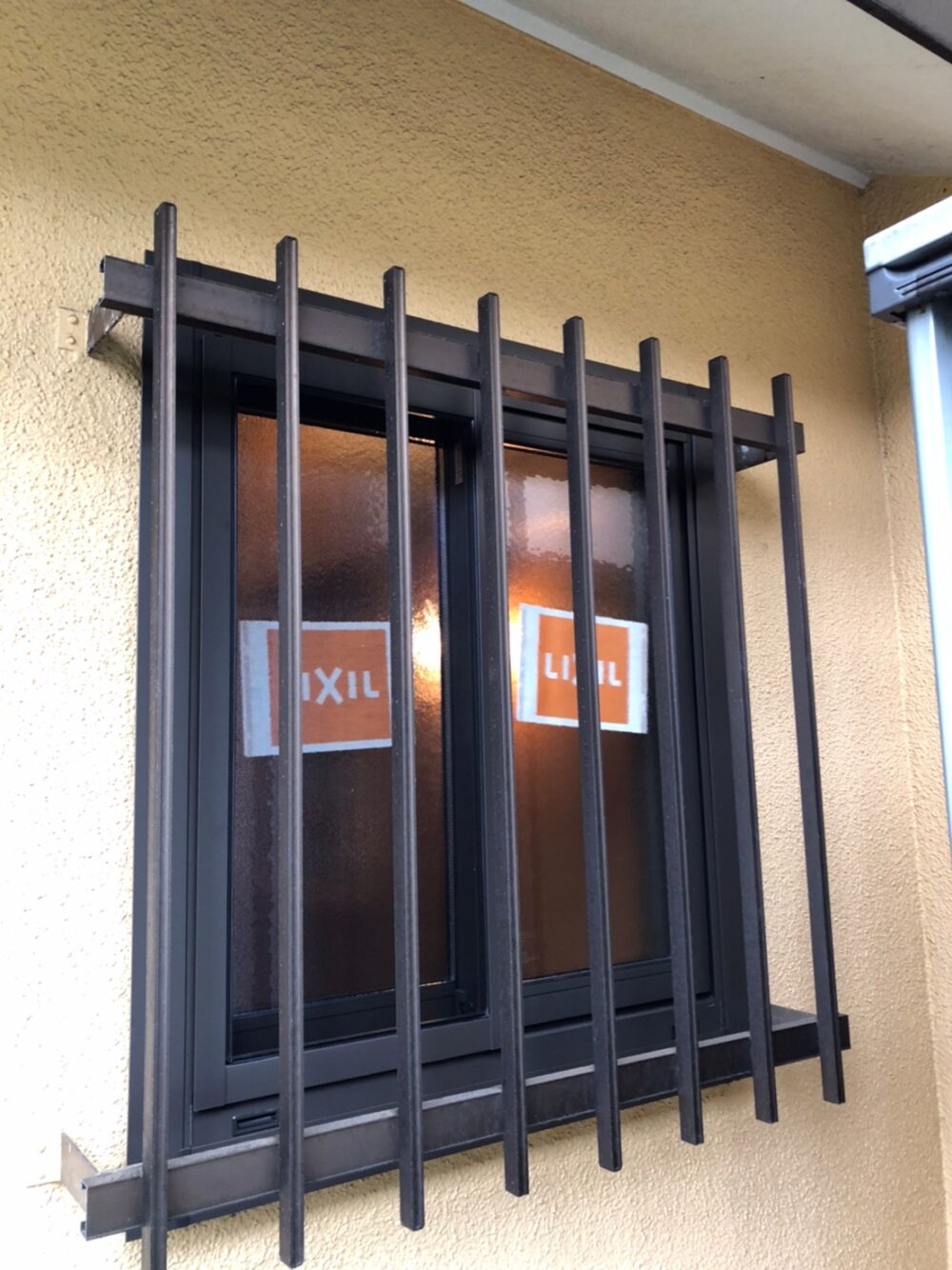 海老名市の窓リフォーム施工後：LIXIL取替窓リプラスでカバー工法を行い断熱性能がアップした窓。面格子も再設置して防犯対策を強化