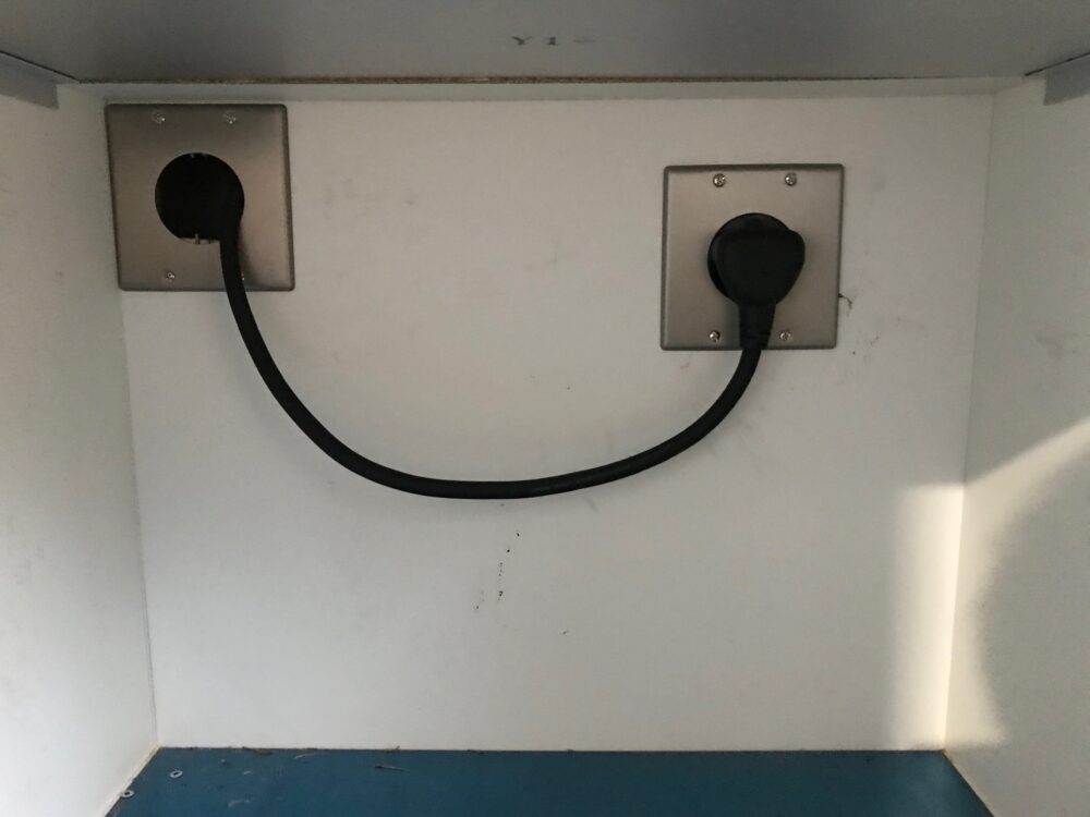 IHクッキングヒーター用の200V専用電源配線工事完了。キッチン背面に設置された専用コンセント。