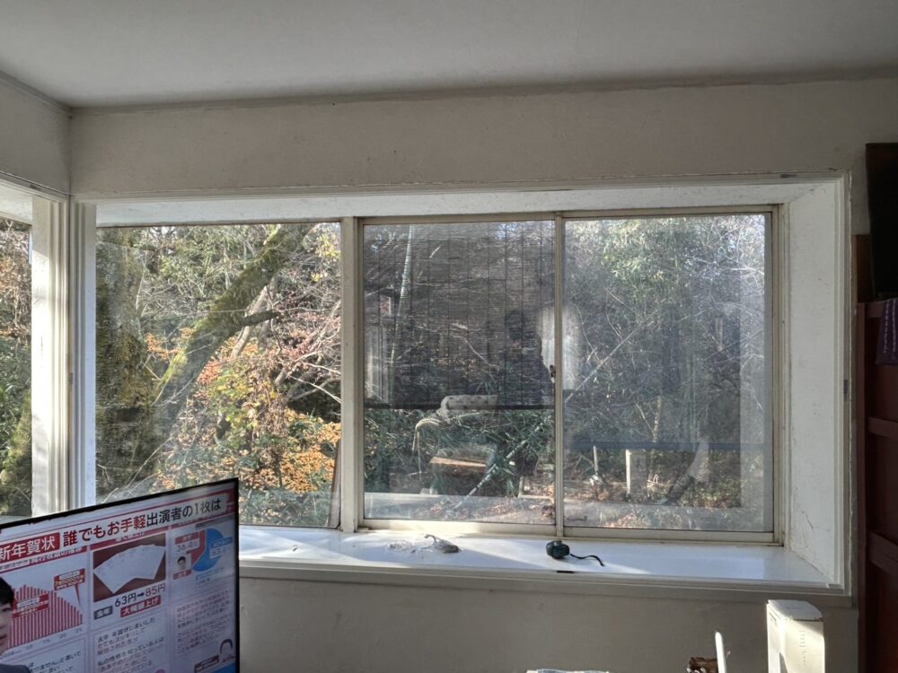 相模原市の戸建てリフォーム施工前。リビングにある大きなL字型コーナー窓の様子。冬場の寒さと結露が課題となっていた既存の窓。 相模原市の戸建てリフォーム施工前。リビングにある大きなL字型コーナー窓の様子。冬場の寒さと結露が課題となっていた既存の窓。